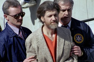 曾在17年間犯下16起郵包炸彈案的美國「大學炸彈客」卡辛斯基（中）於10日凌晨在獄中死亡。圖為他1996年被捕後被帶離法院的資料照片。美聯社