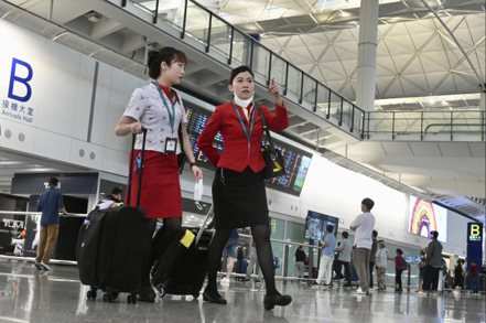 國泰航空宣布空姐7月起加薪3%至8% 。圖為國泰航空的空姐步出香港國際機場大廳。（中新社）