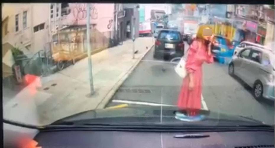 最近有网友在facebook上传车Cam影片，显示1名身穿粉红色长裙的女子站在停车格内“人肉霸位”。（facebook影片截图）