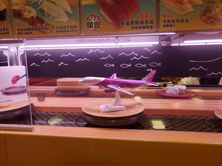 壽司迴轉台上，也可看見樂桃航空的模型機。記者陳睿中／攝影