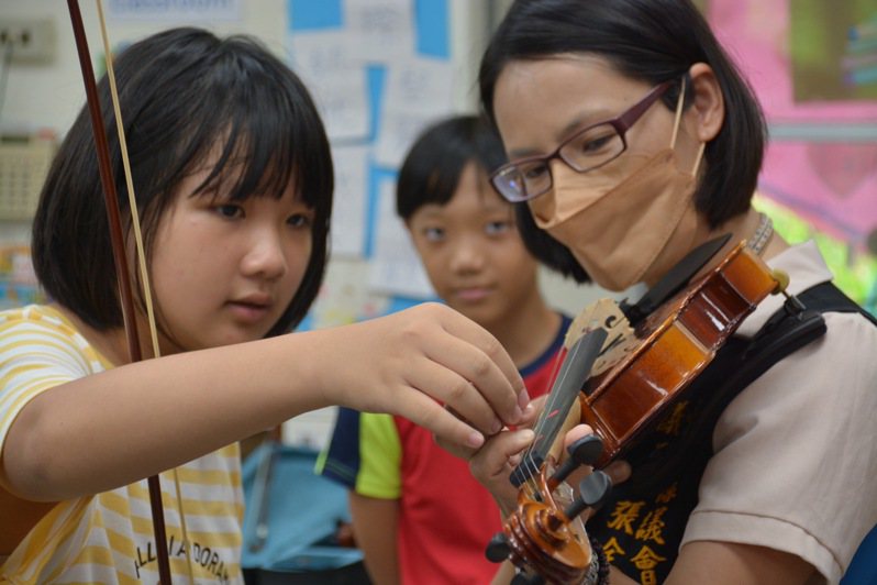 台東縣議員張全馨嵐（右）陪同學童試拉新提琴。記者卜敏正／攝影