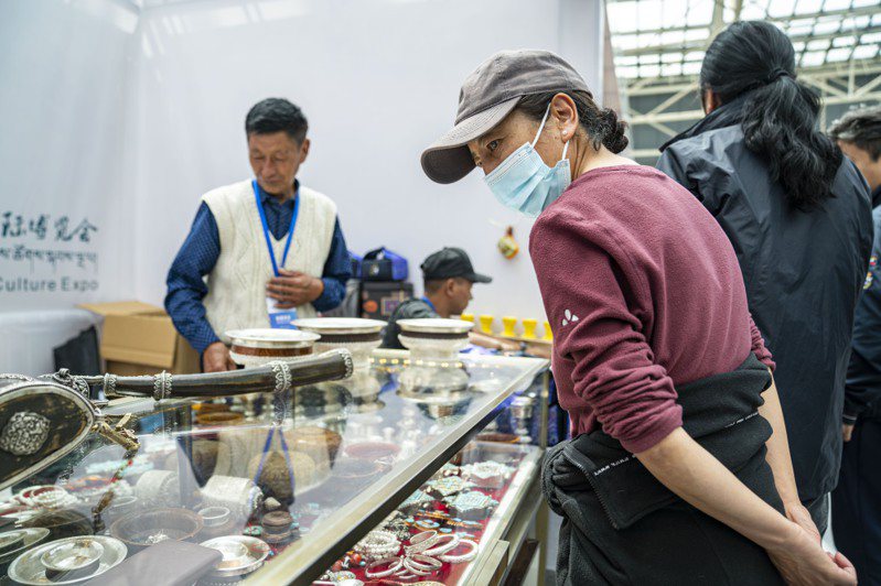 第五屆藏博會日前在拉薩舉行，圖為顧客在觀看藏式工藝品。（新華社）