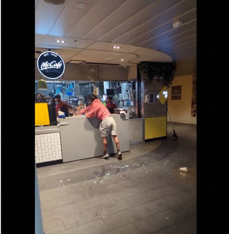 顧客走上前向店員擲食物還擊，還破壞餐廳的收銀機。（影片截圖）