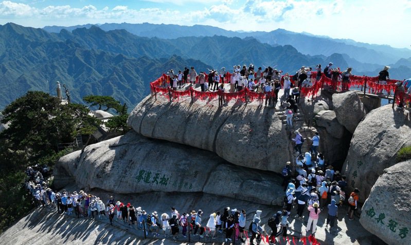 西嶽華山，遊客在工作人員的引導下有序登山，領略「奇險天下第一山」風光。新華社