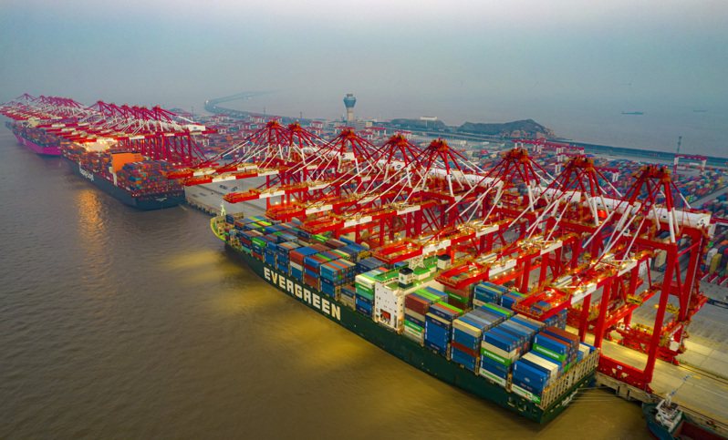 上海洋山港實現「雙檔靠泊」，保障長江內支線集裝箱船舶通行提速。圖為洋山港碼頭燈火通明，多艘大型集裝箱貨輪正在進行裝卸作業。（中新社）