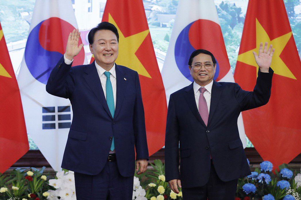 6月底韓國大統領尹錫悅（左）抵達越南進行國事訪問，隨行的是龐大商業代表團，包括三星、現代、LG、SK等財閥掌門人都在其中。右為越南總理范明正。 圖／歐新社