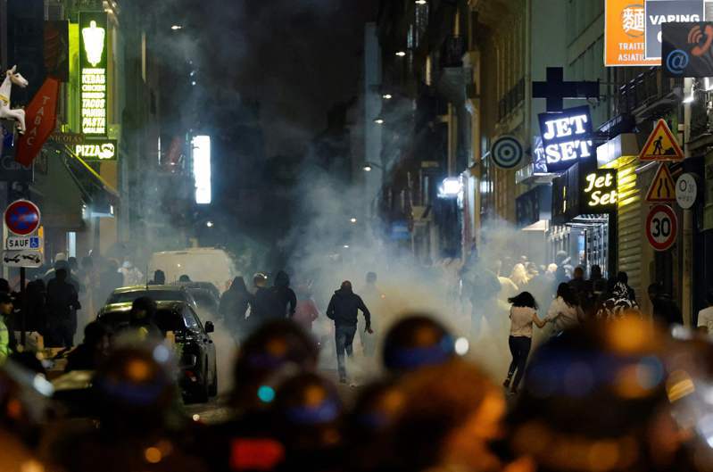 法國警方二日在巴黎使用催淚瓦斯應對群眾，迫使示威者逃離；當晚已是十七歲北非裔少年遭警槍殺後的第六夜，但衝突仍持續。（法新社）