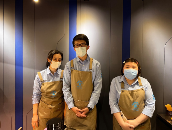 樸樹咖啡廳店長謝佳男（中）與身心障礙者員工（左、右）合影。 圖／高譽文攝影