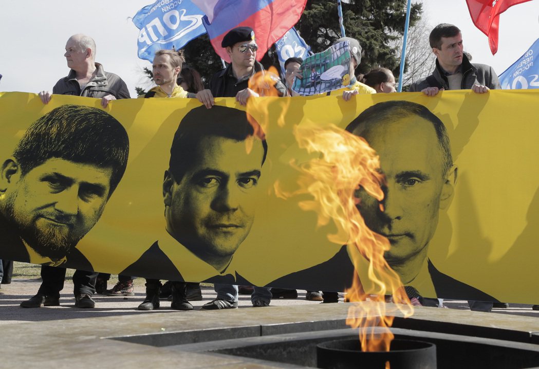 燃燒卡狄羅夫（左起）、梅德維傑夫、普丁照片的抗議者。 圖／美聯社