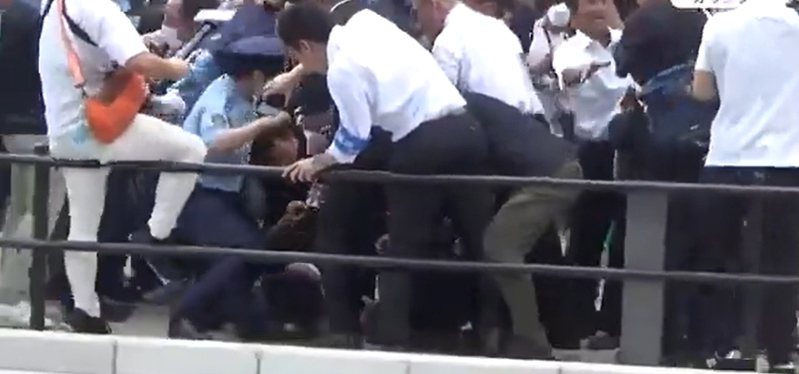 日本每日新聞報導，聽到獻花台附近有人叫喊「有男子手持鐵管」後，引發現場一陣騷動。這名持鐵管的男子被制伏後已遭警方帶離，詳細狀況仍待警方進一步釐清。圖/取自推特