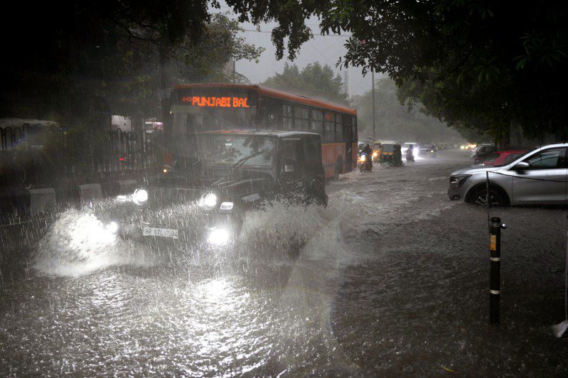 9日，印度新德里的傾盆大雨中，車輛穿過積水的街道。美聯社