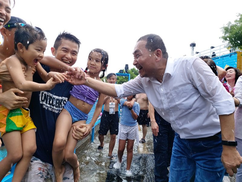 即便被遊客噴水濕身，侯友宜仍親切與民眾互動。記者戴永華／攝影