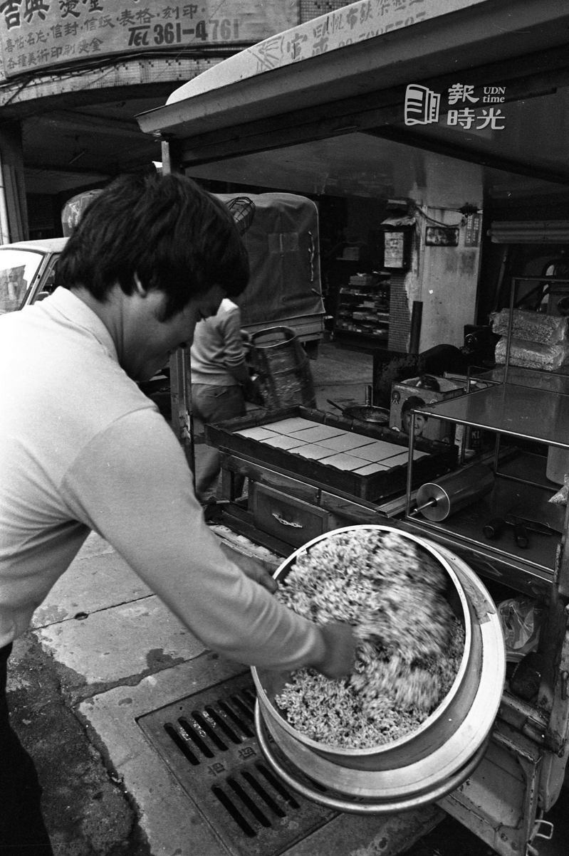 街頭傳統甜點「爆米香」製作過程，圖為爆好的米正在與糖粉拌勻。聯合報系資料照（1985/12/6）
