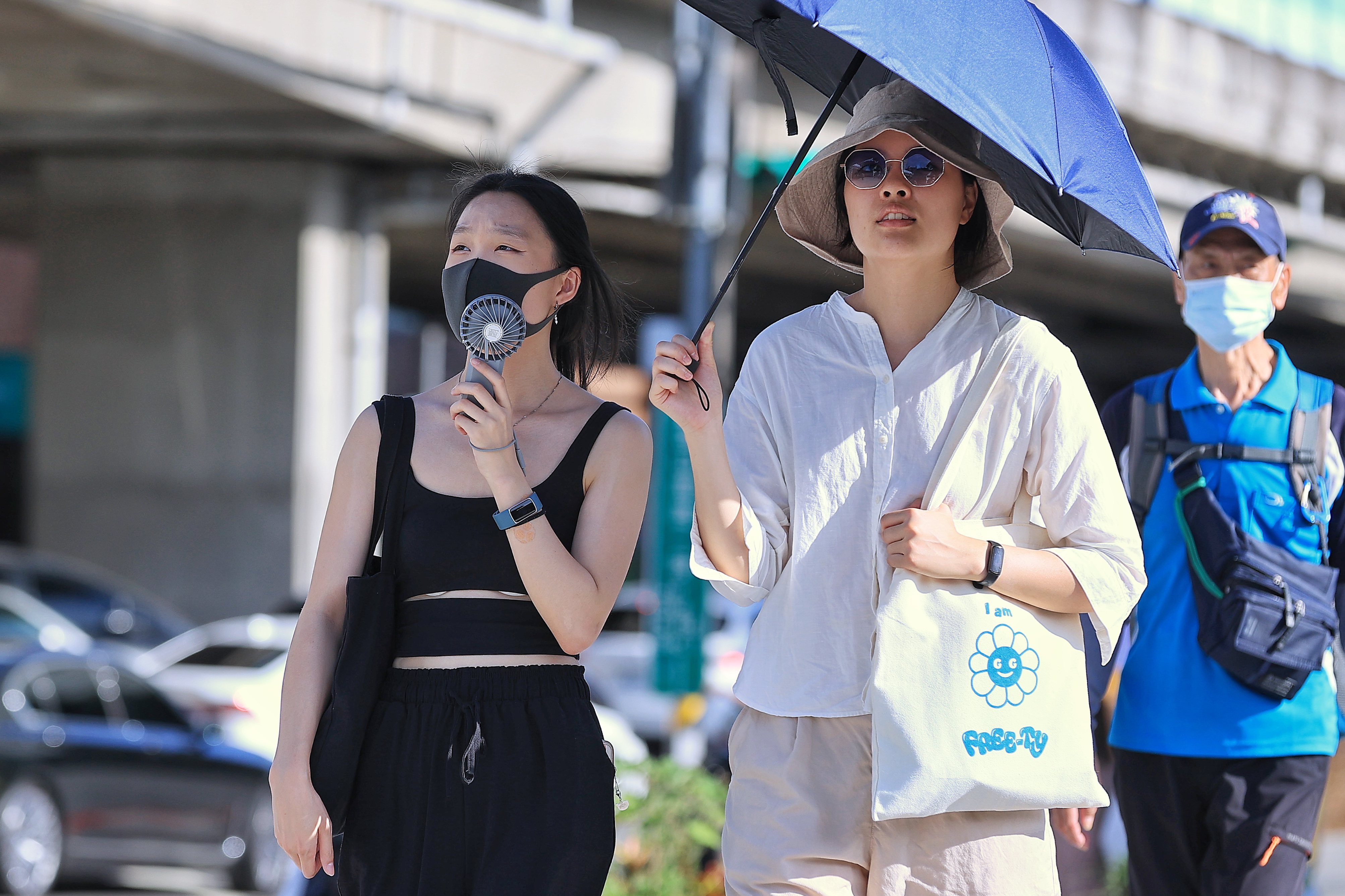 七月以來天氣高溫炎熱，氣象局多次發布高溫警報，各地熱傷害頻傳。圖為台北街頭民眾撐傘遮陽。記者林伯東／攝影