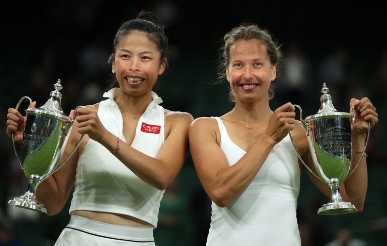 我國網球好手謝淑薇（左）與老搭檔捷克史翠可娃（右）奪得溫網女雙冠軍，開心捧起金盃。 歐新社