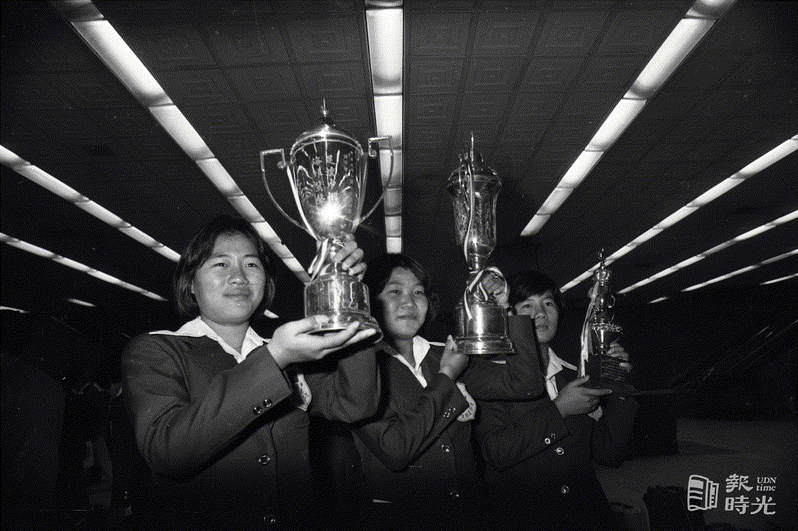 遠征泰國、新加坡及印尼戰績八勝一和的中華木蘭女子足球隊，於廿六日搭乘星航班機，於下午三時四十五分返國，圖為隊員拿著獎盃合照。圖／聯合報系資料照(1977/01/26 程川康攝影)