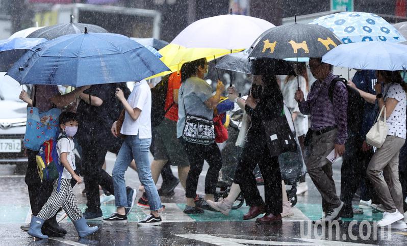 受卡努颱風外圍環流影響，大台北一早降下陣雨，大批通勤族在大雨中撐傘穿越馬路，未來幾天北部也都會有間歇性雨勢。記者侯永全／攝影