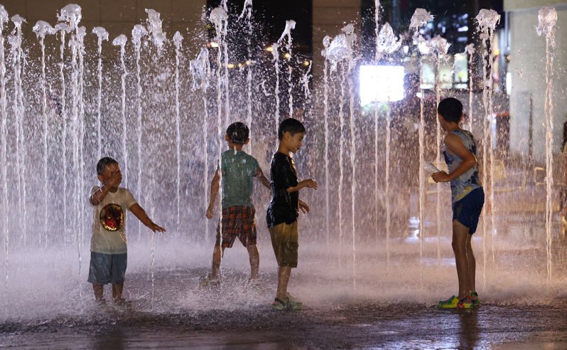 今夏熱浪席捲世界各地，南韓當局統計，今年累計至少23人死於中暑。圖為南韓的小朋友們在首爾光化門廣場前的噴泉玩耍。 歐新社