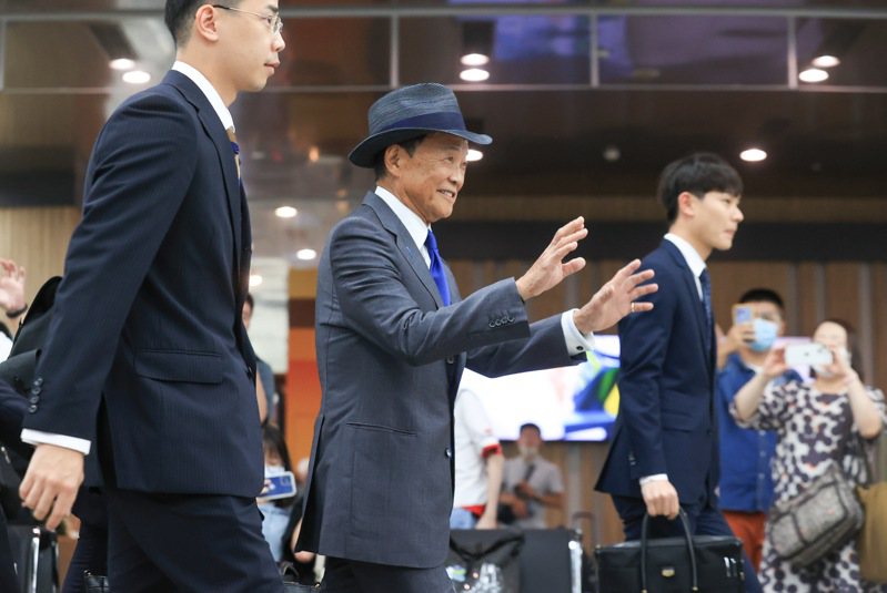 日本前首相暨自民黨副總裁麻生太郎（中）今天率團來台訪問，入境松山機場時遇到許多日本遊客在入境大廳等候，他也揮手向他們打招呼。記者余承翰／攝影