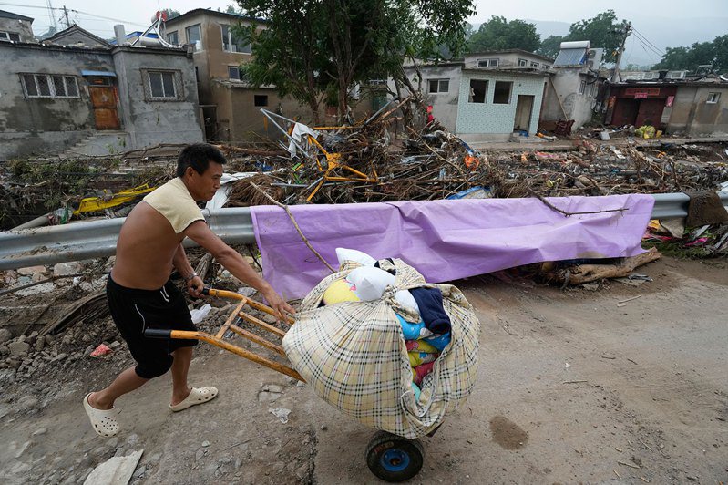 2023年8月4日，北京居民在洪災後的因房子無法居住，搬走家當轉移。（美聯社）