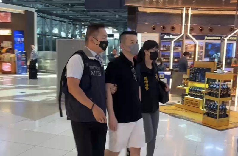 郭哲敏在刑事局與調查局人員押解下，從泰國遣返回台灣。記者廖炳棋/翻攝