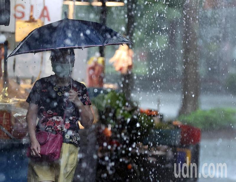 受低壓帶影響，大台北一早下起豪大雨，一位婦女在大雨中前往市場採買。記者侯永全／攝影