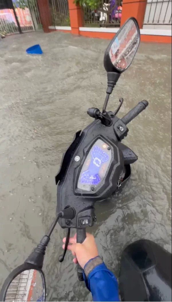 高雄機車騎士今天上午騎進本館路積水處，機車被淹沒只剩龍頭與坐墊露出水面。圖／南部新聞聯盟提供