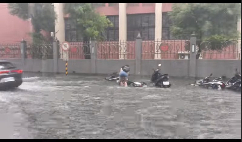 板橋區橋中二街淹水，機車騎士只能在用牽的。圖／擷取自我是板橋人臉書社團
