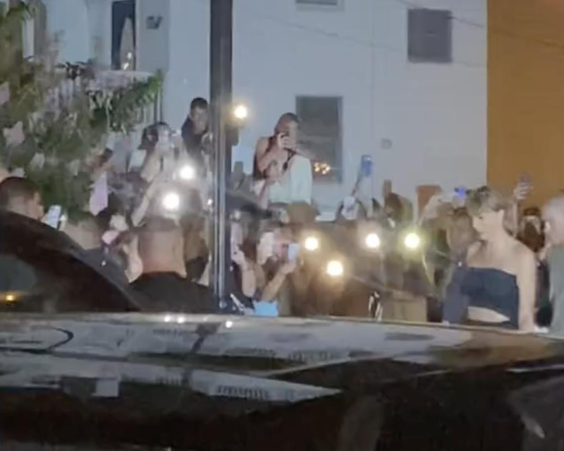 泰勒絲（右）向守在對街的歌迷們揮手致意。圖／摘自TikTok