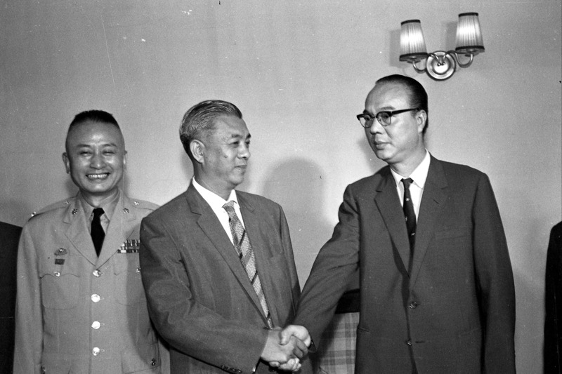 1961年8月28日，周百鍊（中）代理台北市長職務之移接儀式上午9時，於市府市長辦公室舉行，與其握手者為因弊案被停職的市長黃啟瑞（右）。圖／聯合報系資料照片