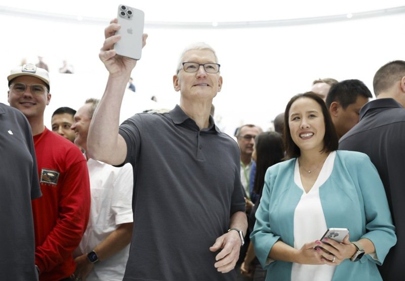 蘋果CEO庫克在發表會上，拿起最新的iPhone。美聯社