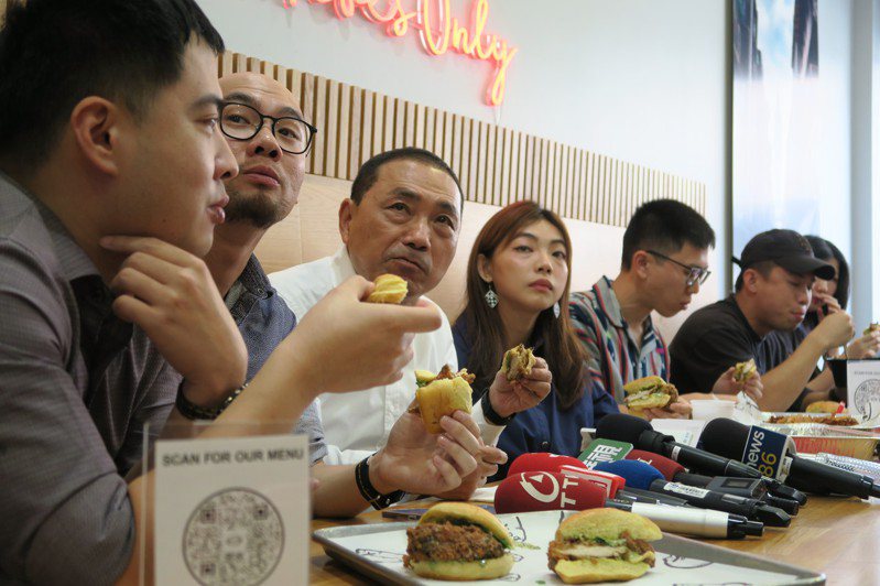 國民黨總統參選人侯友宜（左3）16日在紐約台菜餐廳Yumpling與台灣青年座談，一同品嚐美式雞肉堡。中央社