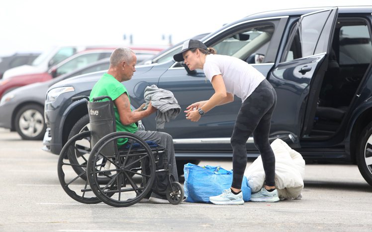 珍妮佛嘉納幫助坐輪椅的無家可歸者。圖／達志影像