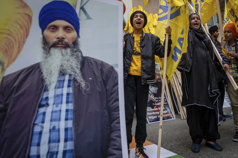 加拿大錫克教領袖尼賈爾（左圖）6月在卑詩省遭刺殺後，抗議群眾在溫哥華的印度領事館外抗議。美聯社