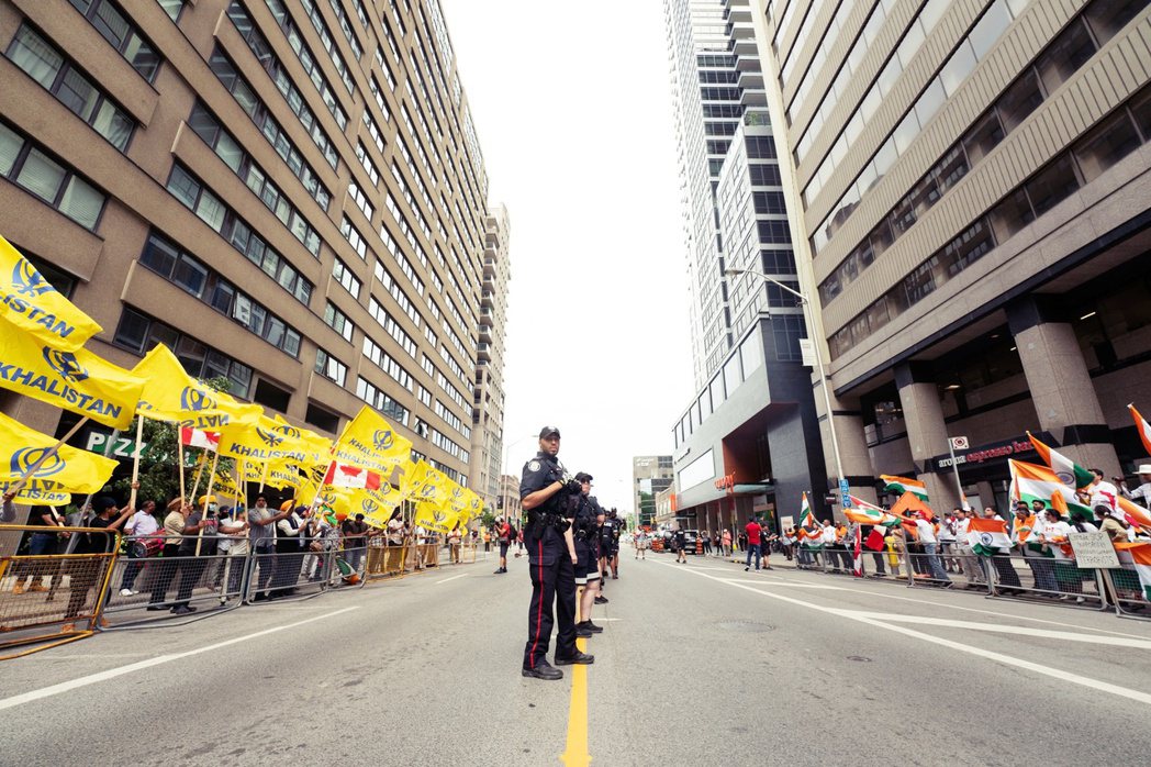 7月8日在加拿大多倫多印度領事館前，警方將抗議支持哈利斯坦運動的錫克教徒（左）與...