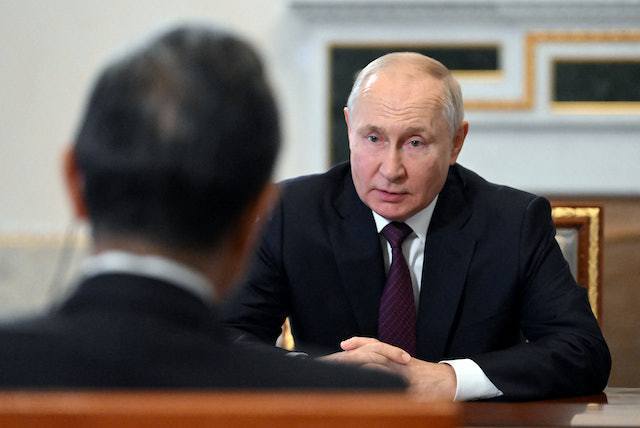 俄羅斯總統普亭9月20日在俄羅斯聖彼得堡會晤中共中央外辦主任王毅（背對鏡頭者）。...