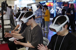2023東京電玩展21日熱鬧登場，今年全球最火熱的AI（人工智慧）話題，同樣燒進東京電玩展，成為主題論壇的焦點，圖為參觀者體驗VR遊戲。歐新社