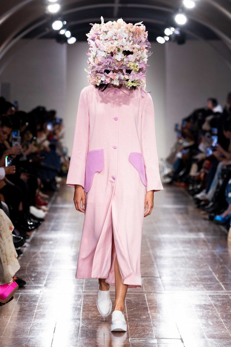 模特兒走秀的第一套，粉紅色花卉裝置頭盔，像面臨衝擊後滿溢、盛放的生機。圖／APU...