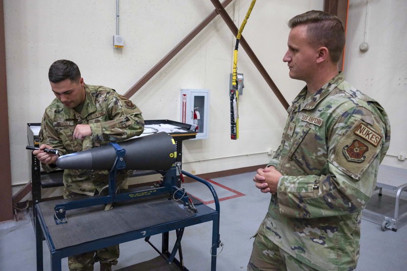 美國空軍中士曼杜拉（左）在懷俄明州的彈藥中隊示範，如何檢查彈頭上是否有細微刮痕。美聯社