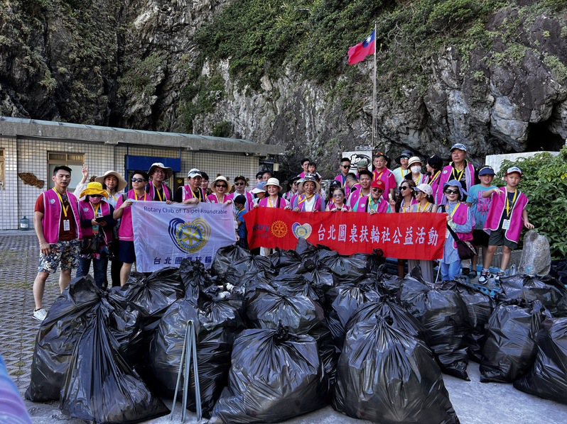 台北圓桌扶輪社成員今天搭船到基隆嶼淨灘，從海岸回收39大袋海洋廢棄物。圖／基隆市天行者慈善協會提供