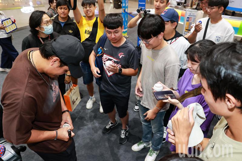 張育成（左一）逐一為粉絲在棒球上簽名。記者黃仲明／攝影