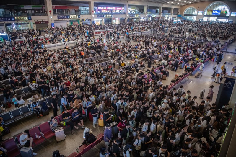 中國中秋、十一長假29日啟動，大批旅客聚集各大火車站。圖為湖北漢口站候車大廳的旅客。（新華社）