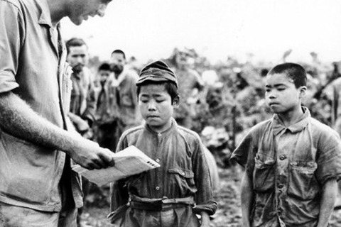 圖為沖繩戰時，美軍向沖繩孩童問話。 圖／維基共享
