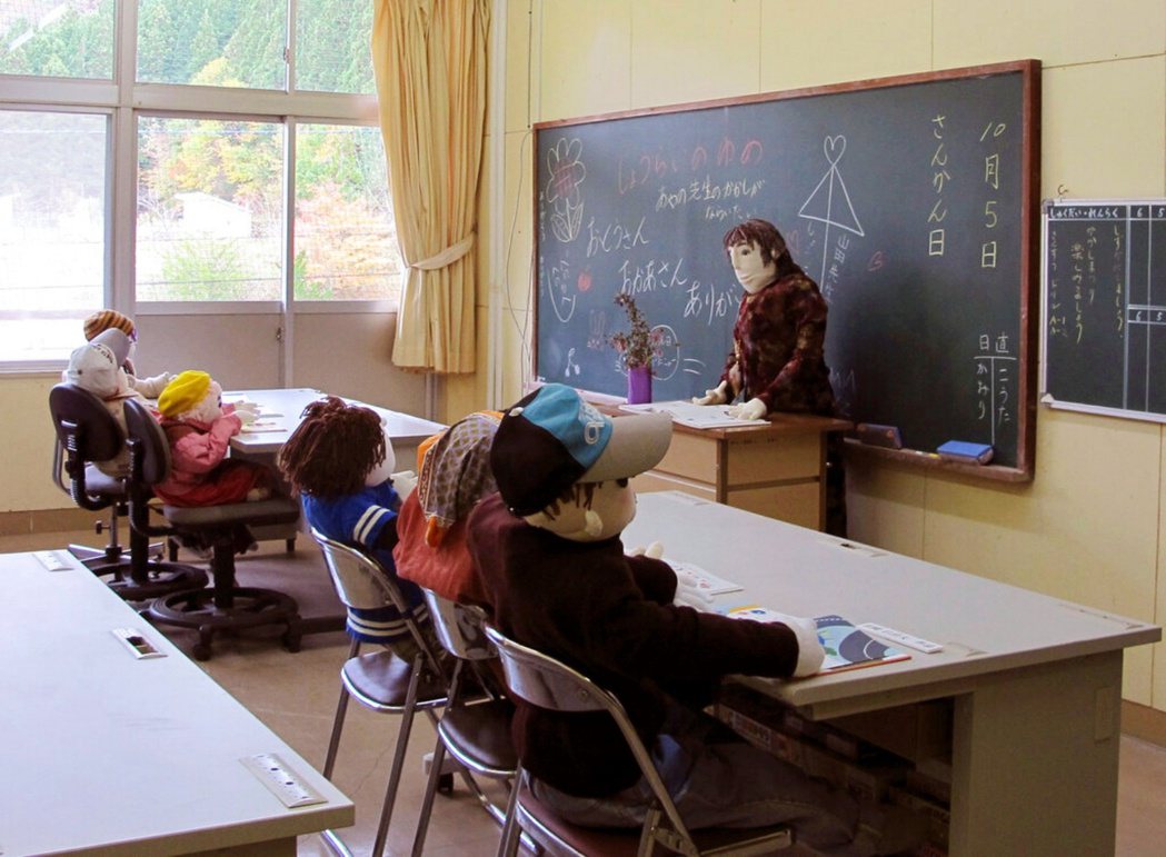 名頃村空置的學校中，稻草人排排放置在教室中。 圖／美聯社　　