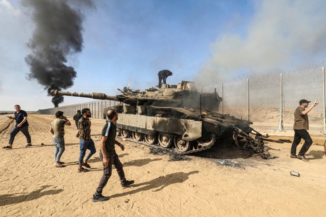 巴勒斯坦人越過以巴邊境圍欄，控制一台以色列坦克。 圖／美聯社