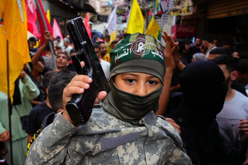拿槍的巴勒斯坦男孩，其他人在慶祝哈瑪斯對以色列發動攻擊。 圖／美聯社