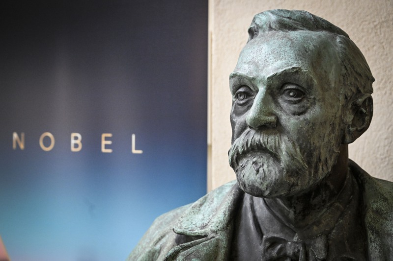 諾貝爾委員會公布得主的記者會場邊，有諾貝爾的雕像和姓氏。美聯社