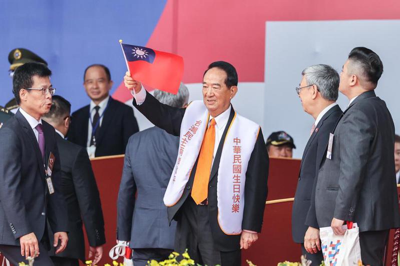 國慶大典上，親民黨前主席宋楚瑜（中）穿著自製背心，印有「中華民國生日快樂」，並且在結束時特別起立揮舞國旗。記者曾原信／攝影