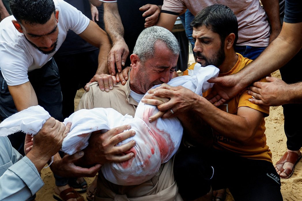 10月11日，加薩南部汗尤尼斯，巴勒斯坦人埋葬在以色列空襲中喪生的孩子遺體。 圖...