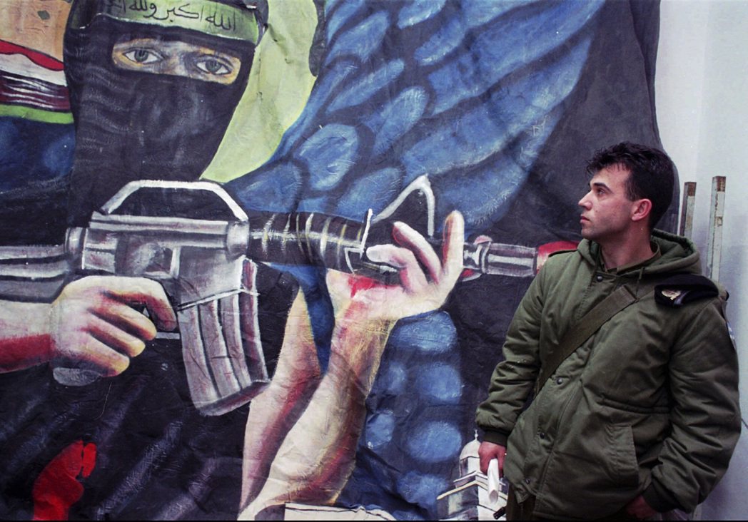 位於以色列的街頭壁畫，上方描繪的恐怖份子手持機槍，頭部捆著哈瑪斯的標誌性綠色旗幟...